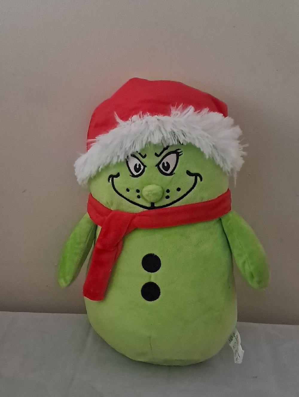 Festive Green Plush Character with Red Hat and Scarf